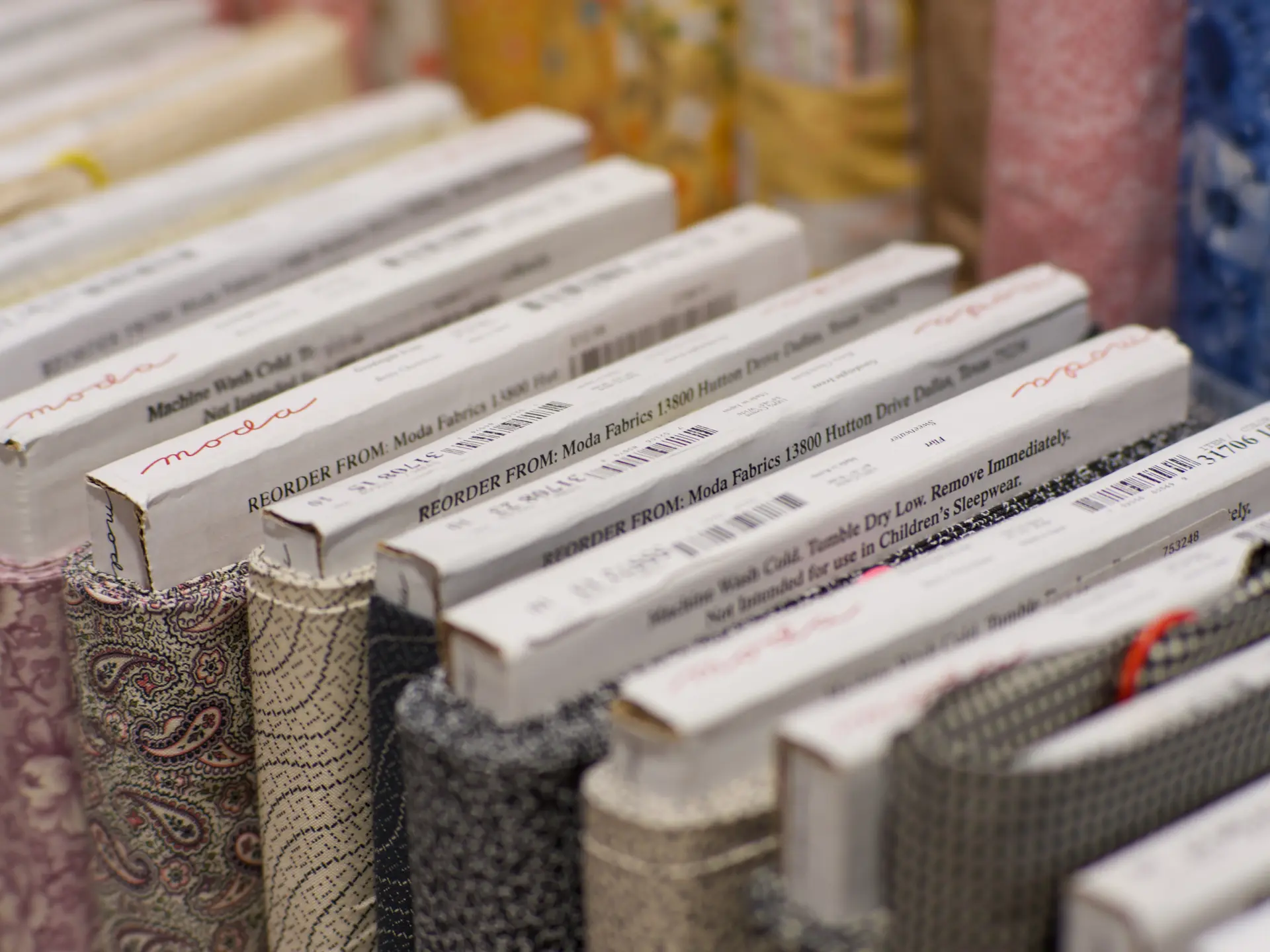 Bolts of fabric arranged on a shelf